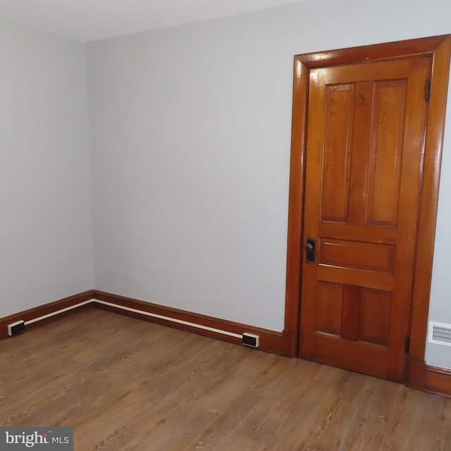 empty room featuring light wood-style flooring and baseboards