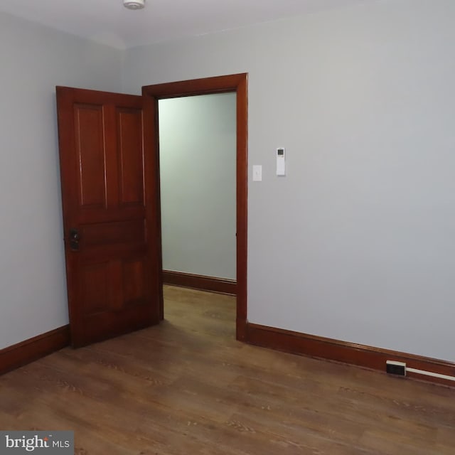 unfurnished room with wood finished floors and baseboards