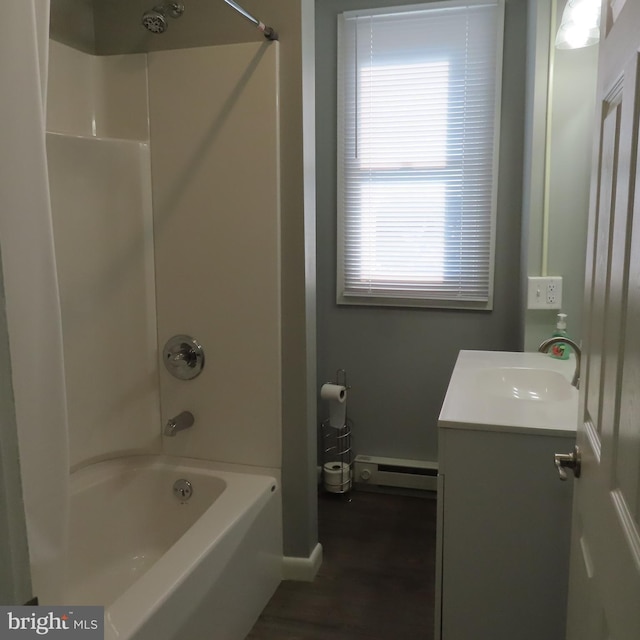 bathroom featuring a baseboard radiator, baseboards, shower / washtub combination, and vanity