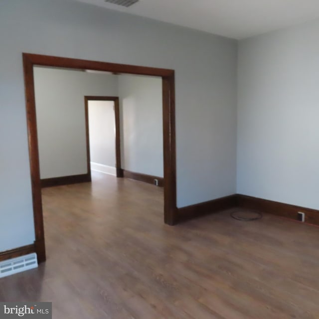 empty room featuring baseboards, visible vents, and light wood-style floors