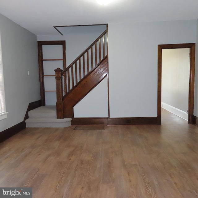 stairs with wood finished floors and baseboards