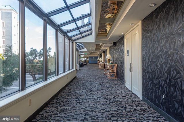 hall with baseboards and carpet flooring