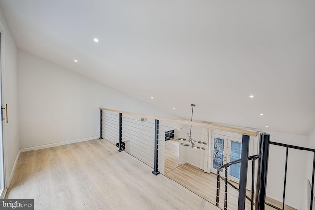 interior space featuring light wood-type flooring, baseboards, vaulted ceiling, and recessed lighting