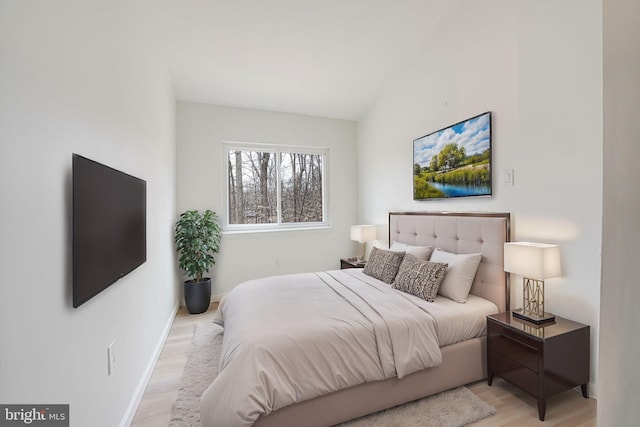 bedroom featuring light wood-style floors and baseboards