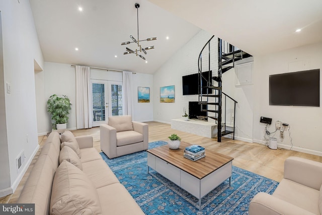 living area featuring french doors, lofted ceiling, visible vents, stairway, and light wood-style floors