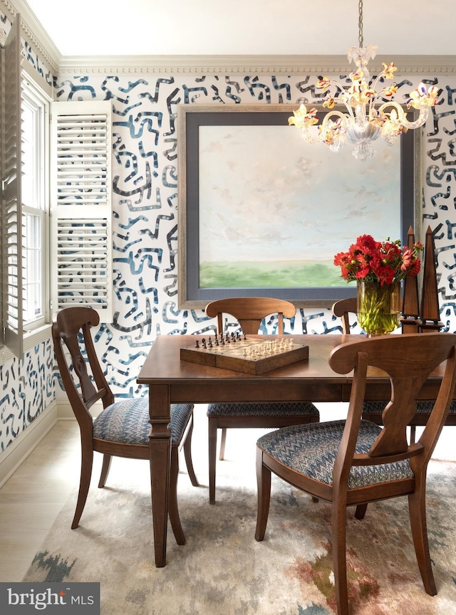 dining room featuring wallpapered walls, a healthy amount of sunlight, ornamental molding, and an inviting chandelier