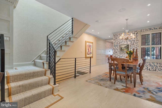 dining room with stairway, wood finished floors, recessed lighting, crown molding, and a chandelier