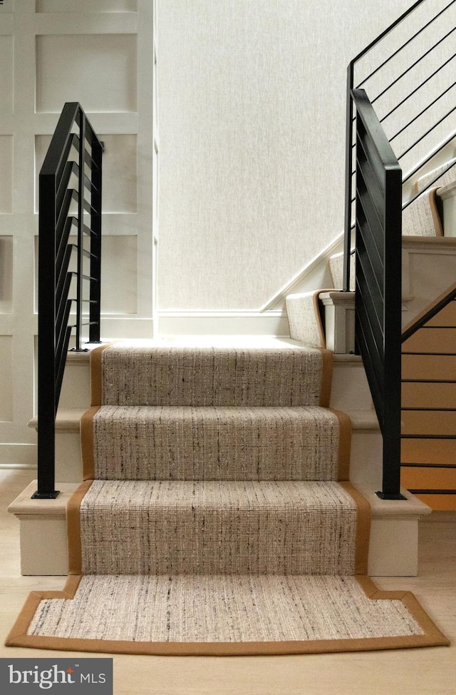 stairway featuring built in features and wood finished floors