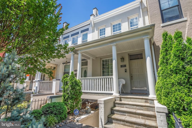 property entrance with brick siding and covered porch