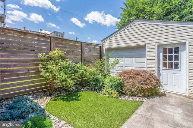 view of yard featuring an outbuilding, a garage, and fence