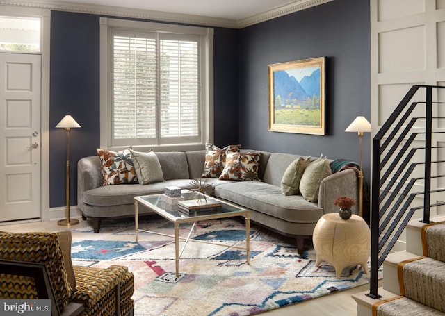 living area featuring stairway, wood finished floors, and ornamental molding