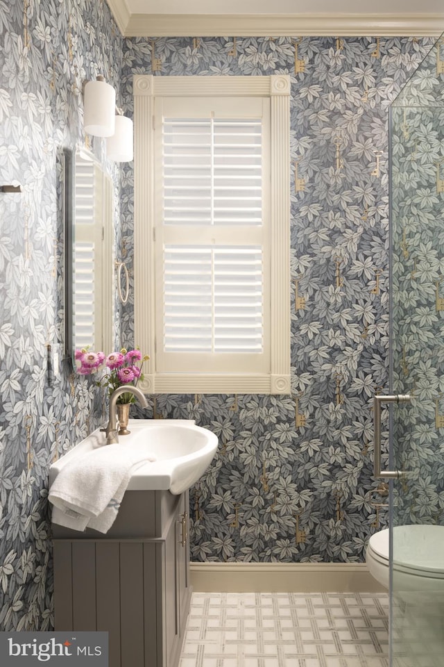 bathroom featuring vanity, baseboards, wallpapered walls, tile patterned floors, and toilet