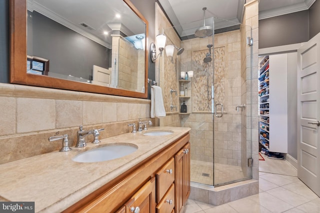 bathroom with visible vents, ornamental molding, a shower stall, and a sink