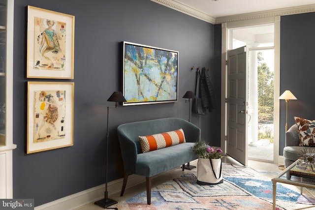 living area featuring baseboards and ornamental molding