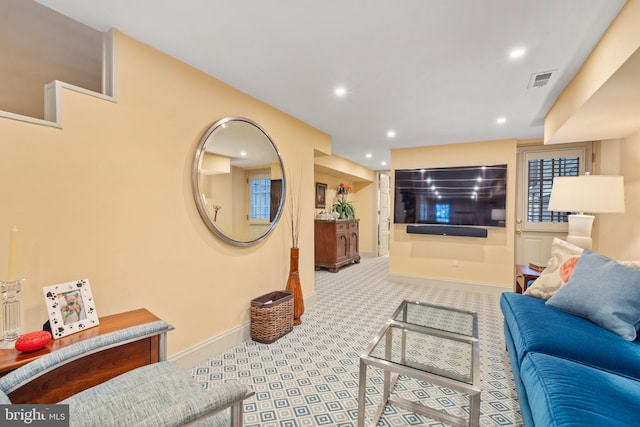 carpeted living area featuring recessed lighting, baseboards, and visible vents