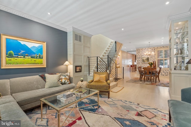 living area with visible vents, a notable chandelier, wood finished floors, recessed lighting, and stairs