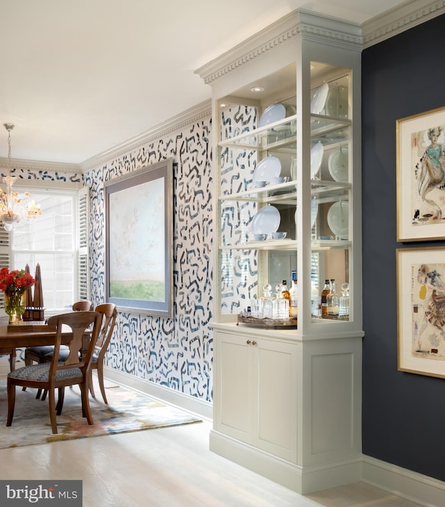 dining area with a notable chandelier, wallpapered walls, baseboards, and wood finished floors