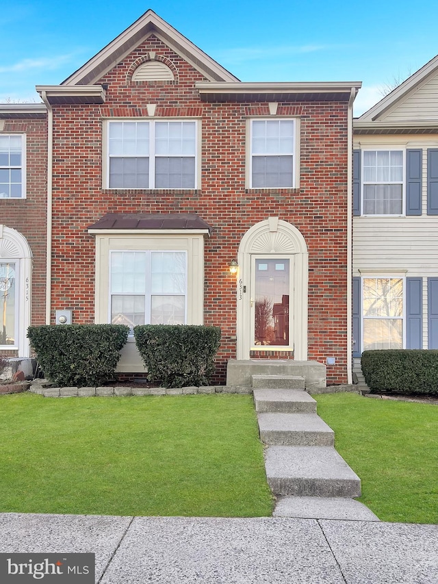 view of front of home featuring brick siding and a front yard