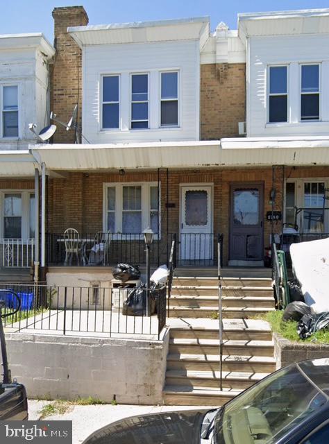 multi unit property featuring covered porch and brick siding