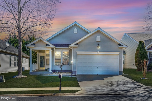 view of front of property with concrete driveway, a front lawn, and an attached garage