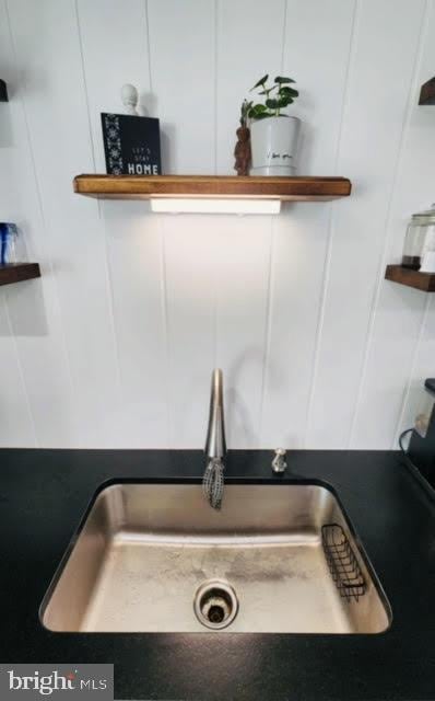 interior details with open shelves, a sink, and white cabinets