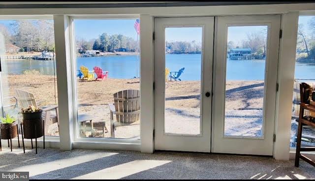 doorway featuring carpet floors, french doors, and a water view