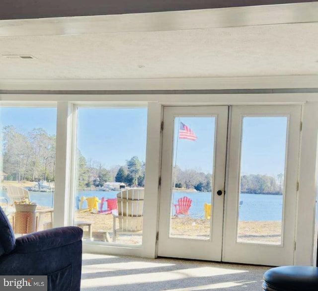 doorway featuring french doors, a water view, and visible vents