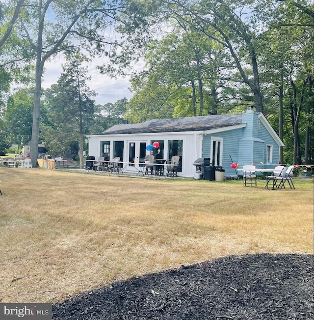 view of front of house with a chimney and a front lawn