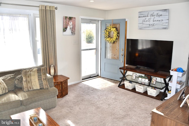 living room featuring light colored carpet and baseboards