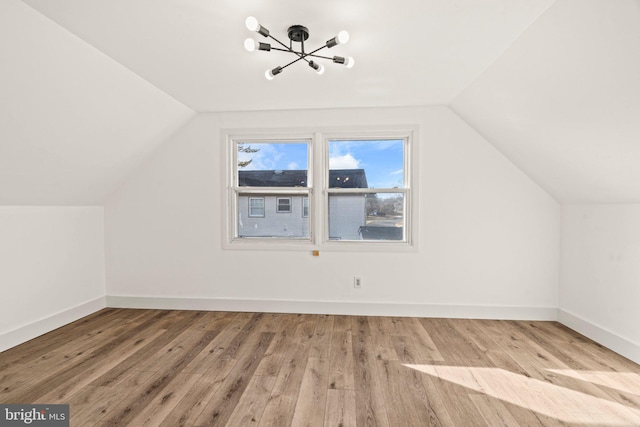 bonus room featuring lofted ceiling, light wood finished floors, and baseboards