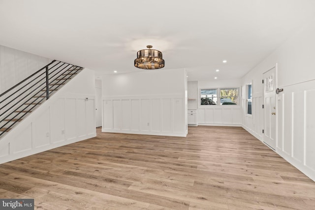 entrance foyer with light wood-style floors, recessed lighting, a decorative wall, and stairway