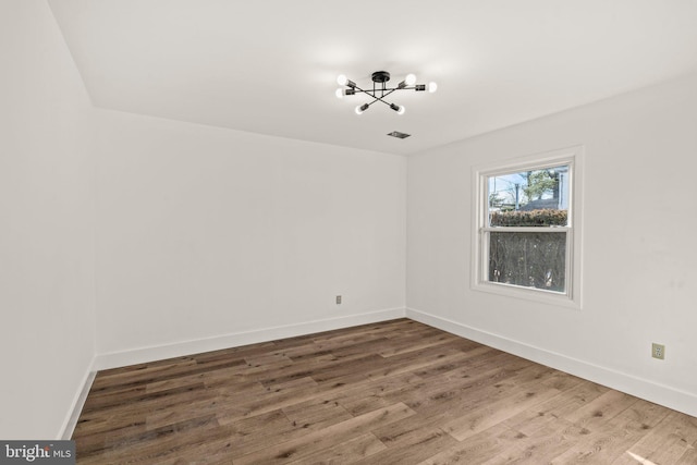 empty room featuring wood finished floors and baseboards