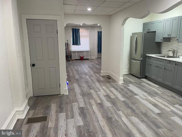 kitchen featuring visible vents, arched walkways, light countertops, and a sink