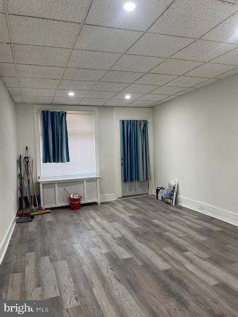 empty room featuring radiator, baseboards, and wood finished floors