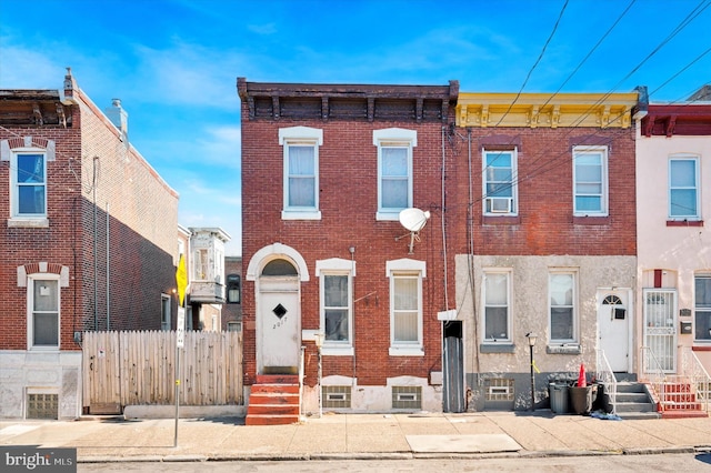 multi unit property featuring entry steps, brick siding, and fence