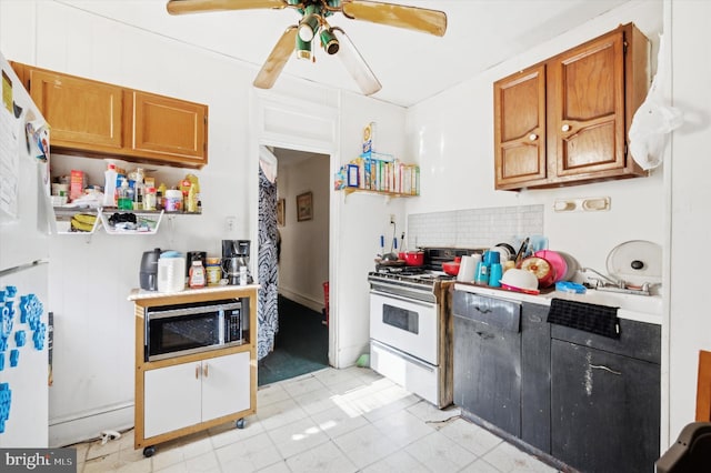 kitchen featuring white appliances, a sink, a ceiling fan, backsplash, and brown cabinets