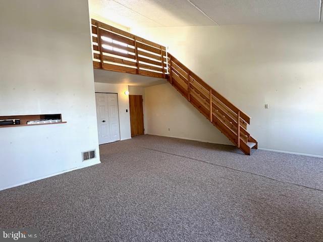 808 Stratford Dr Unit 32, State College, PA 16801 - additional living space with stairway, a high ceiling, visible vents, and carpet flooring