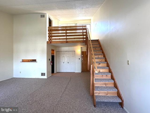 808 Stratford Dr Unit 32, State College, PA 16801 - staircase featuring carpet floors, a towering ceiling, and visible vents