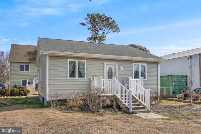 bungalow featuring crawl space, a shingled roof, and a front lawn