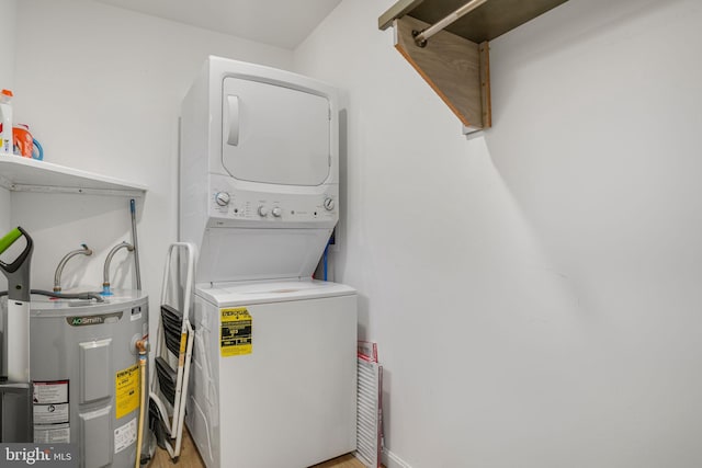 clothes washing area with water heater, stacked washer and dryer, and laundry area