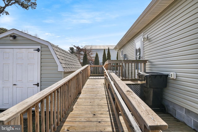 wooden terrace with a storage shed and an outdoor structure