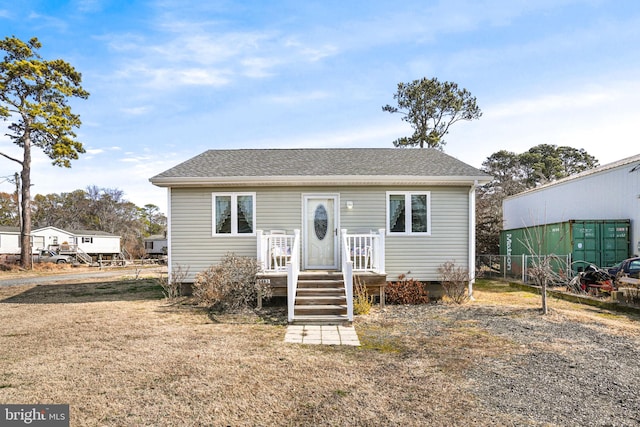 view of front of property featuring fence and roof with shingles