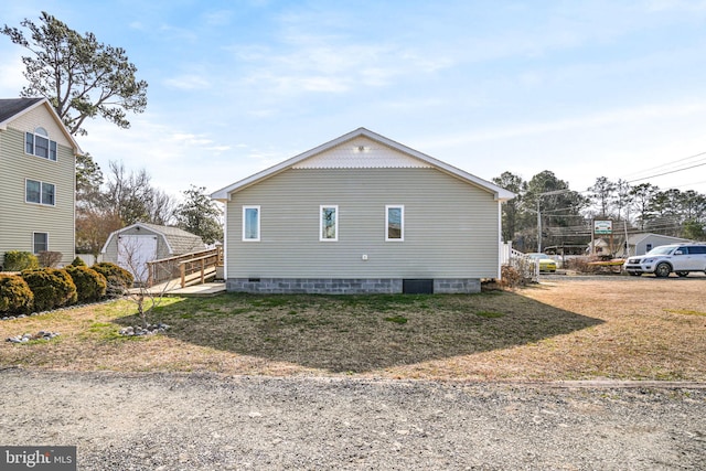 view of side of home with an outbuilding and a lawn