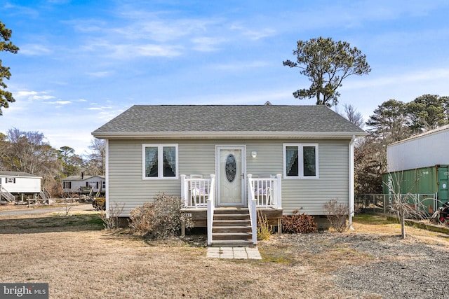 bungalow with crawl space, a shingled roof, and fence