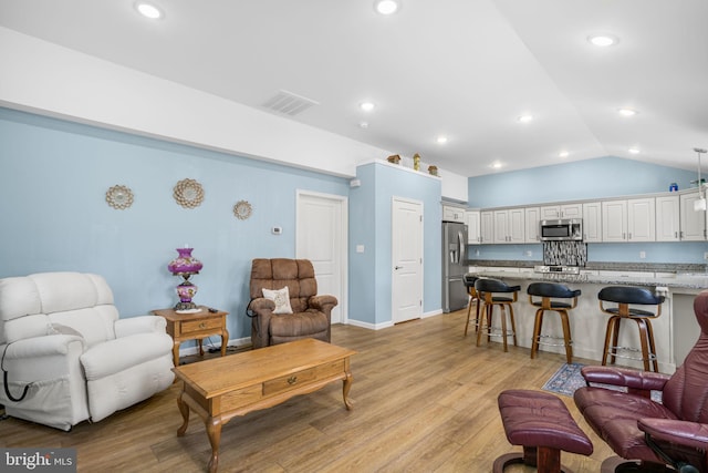 living room with lofted ceiling, light wood-type flooring, visible vents, and recessed lighting