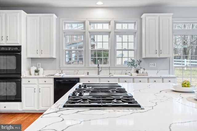 kitchen with dobule oven black, dishwashing machine, stainless steel gas cooktop, white cabinetry, and a sink