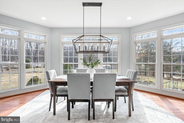 dining room featuring a healthy amount of sunlight, recessed lighting, wood finished floors, and an inviting chandelier