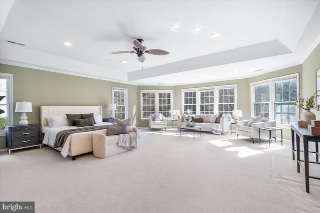 carpeted bedroom featuring recessed lighting, a ceiling fan, visible vents, ornamental molding, and a tray ceiling