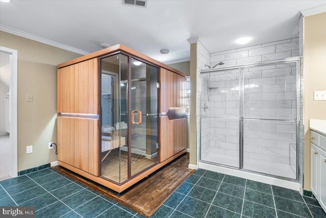 bathroom with a stall shower, tile patterned flooring, baseboards, and crown molding