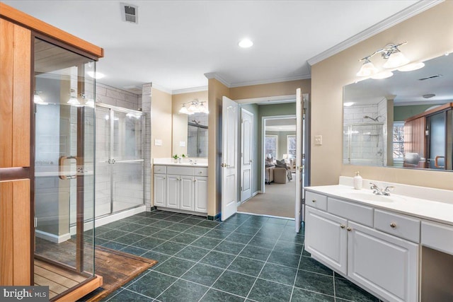 ensuite bathroom with crown molding, two vanities, visible vents, a stall shower, and a sink